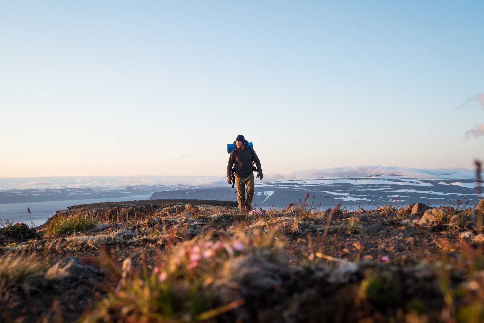 Maður á göngu uppi á fjalli. Í baksýn er Ísafjarðardjúp.